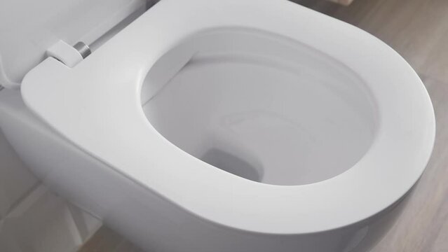 Opening the toilet lid. Modern plumbing, water supply and sewerage. Hygiene rules when using the toilet. 