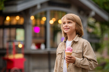 cute little boy eating ice cream outdoors.