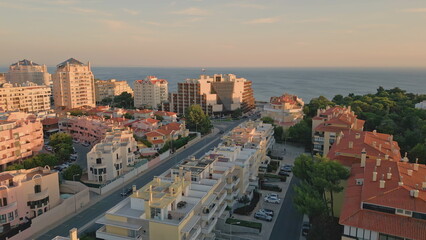 Fototapeta premium Drone twilight coastal town placed at endless ocean. Wonderful seaside town