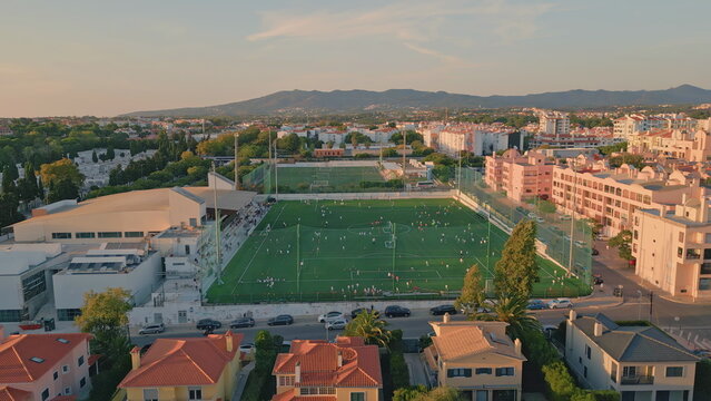 Drone small town stadium under evening sunlight. Beautiful football green field 