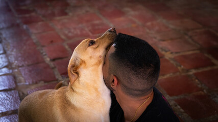 Latin guy cuddling and loving a dog