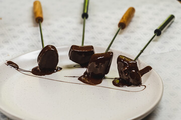 Confectionery with different flavors lie on plate in outdoor pastry shop. Chocolate candies with...