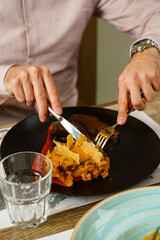 Man eating mac and cheese and slices of meat