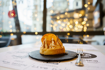 Orange cake with cream on top and led lights in the background