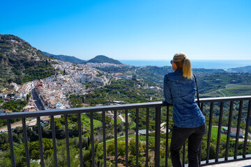Fototapeta na wymiar Blond woman enjoying view over white hillside village of Frigiliana Spain
