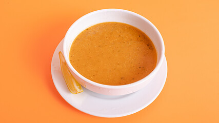 Lentil soup bowl isolated on orange