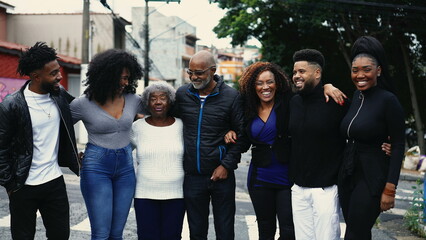 Obraz premium Group of Joyful Brazilian people smiling and laughing together standing in city street posing for camera. United Family of African descent embrace