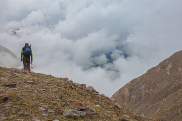 Fototapeta premium Alpine highlands countryside. Higher part of alpine valley in a cloudy day with unrecognizable mountaineer on ancient moraines . Vallelunga, Alto Adige Sudtirol, Italy