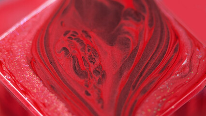Ink background. Glitter paint. Color fluid mix. Captivating hypnotic macro abstract design red...