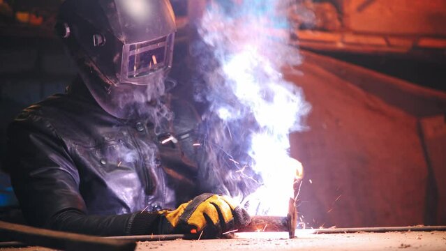 welding worker close up. newbie man learning to solder metal in his garage