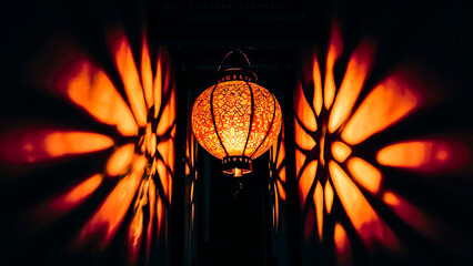 A stunning, atmospheric photograph of a single decorative lantern illuminating the darkness