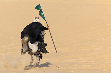 Saudi man in traditional clothing in the desert  carrying a flag of Saudi Arabia while riding a white horse