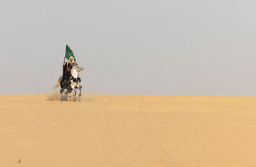 Saudi man in traditional clothing in the desert  carrying a flag of Saudi Arabia while riding a white horse