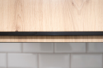 Kitchen wooden cabinet above the work surface. White brickwork in the kitchen.