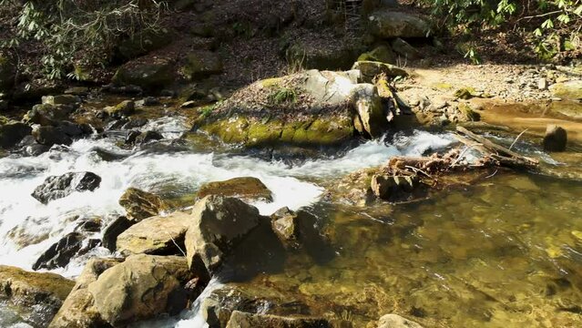 panning footage of the rushing water, rocks and waterfall at Anna Ruby Falls with lush green trees and plants in Helen Georgia USA