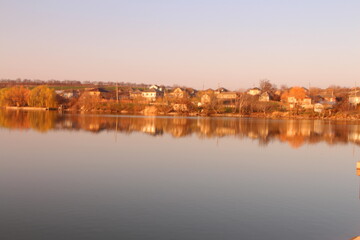 Obraz premium A body of water with trees and buildings in the background