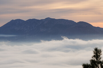 Paisaje de amanecer con silueta de la cadena montañosa La Serrella en la provincia de Alicante y nubes bajas, España
