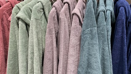 terry bathrobe. soft organic cotton robes of different colors hang on hangers