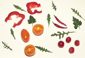 Fresh raw, natural vegetables on a white background, concept. Peppers, red and yellow tomatoes, red peppers, herbs.