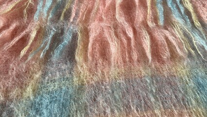 Mohair. Warm knitted blanket with pink and blue geometric pattern. Pink wool texture mohair scarf...