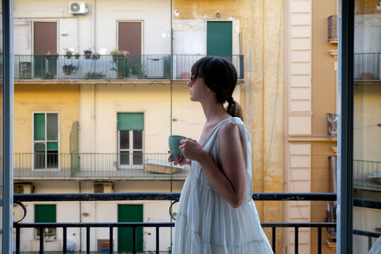 Woman At City Balcony Holding Cup Of Tea
