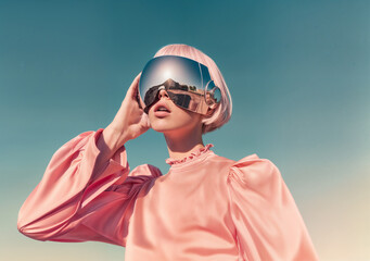 A woman with pink bobbed hair and pink VR headset over sky background