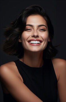Portrait of a Beautiful model woman who has a big smile laughing with clear facial skin dark black curvy hair black shirt