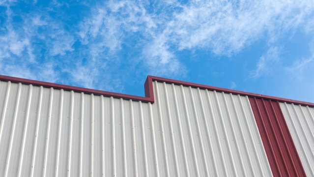 Fachada blanca en nave industrial  y cielo nublado