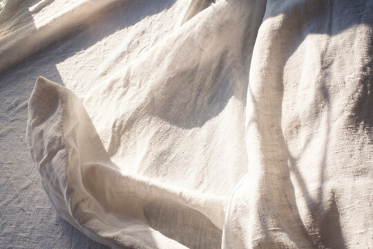 Close-up of neutral beige linen and soft sunlight