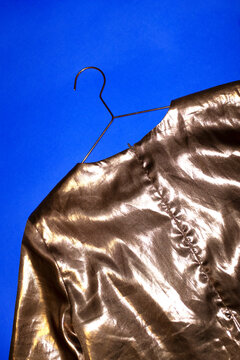 Rosegold/copper t-shirt on blue background and hard direct flashlight