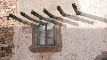 VIgas de madera saliendo en pared de casa abandonada