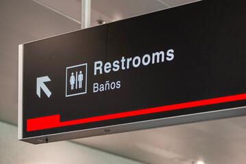 Restrooms sign on black color with the information on white color