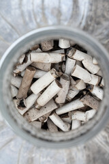 close up of a pile of cigarette butts inside a plastic can. Pollution concept