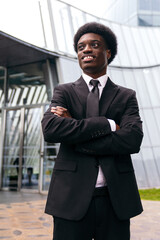 Pensive african young entrepreneur outside a modern facade.