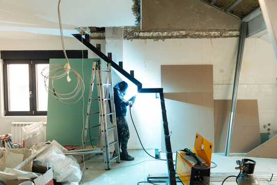 Welder works on the staircase framework.