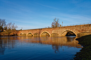 Fototapeta premium Alte Saalebrücke über die Fränkische Saale in Euerdorf, Landkreis Bad Kissingen, Unterfranken, Bayern, Franken, Deutschland