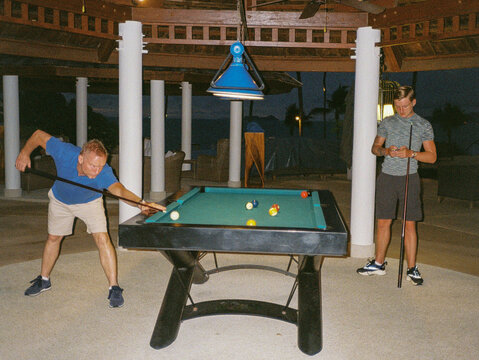Father and son playing a game of pool