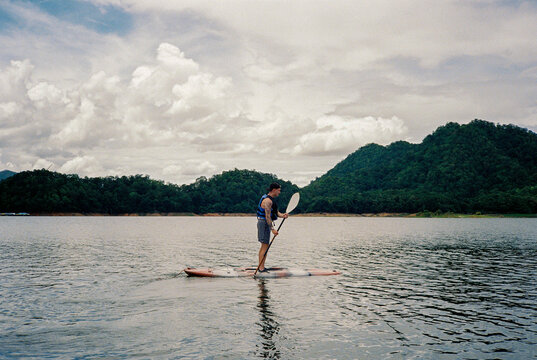 Analogue photo of man on a SUP on a Thai lake
