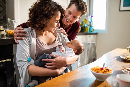 New parents with their baby at the dining table