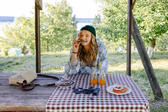Woman playing harmonica sitting at a picnic table 