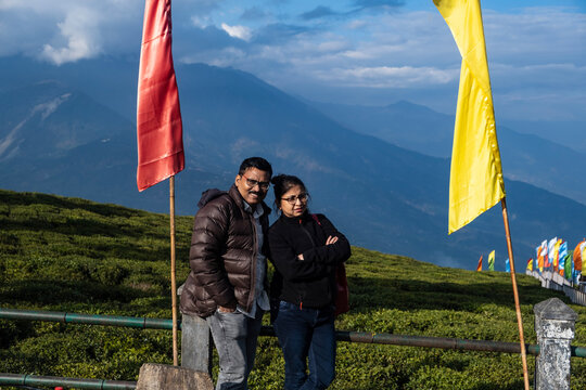 Indian couple enjoying holiday in a mountain with tea garden backdrop