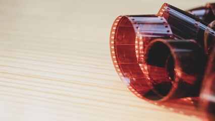 35mm photographic film, color negative film on wooden table background.Vintage equipment for old...