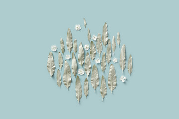 Silver colored leaves and white flowers in blue studio