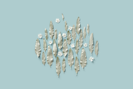 Silver colored leaves and white flowers in blue studio