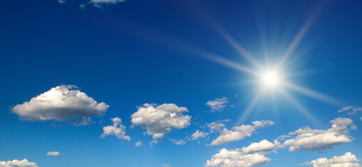 Bright sun on beautiful blue sky with white clouds.