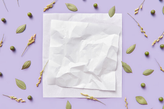 Crumpled paper decorated with green leaves, buds and oat sprigs