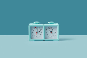 Turquoise colored chess clock standing on duotone background