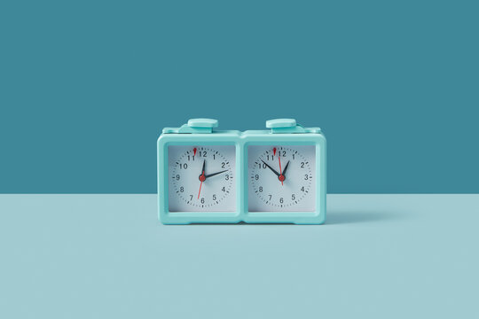 Turquoise colored chess clock standing on duotone background