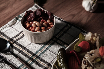traditional turkish white beans stew with bacon, boiled rice and salted marinade vegetables, cucumbers, green tomatoes, carrot, pepper, served ready to eat kuru fasulye