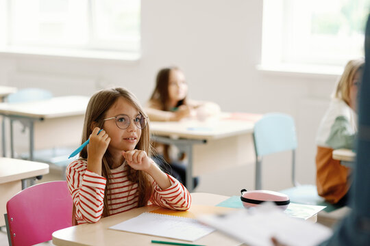 Pupil focused studying primary classroom lesson excited